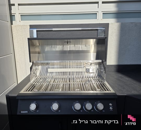 גריל גז בחצר עם רקע של צמחייה